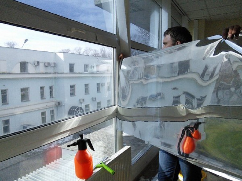 Процесс монтажа солнцезащитной зеркальной пленки на пластиковые окна